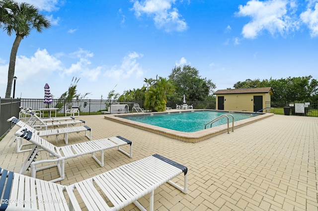 view of pool with an outbuilding and a patio