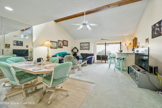 carpeted dining room with beamed ceiling, a textured ceiling, and high vaulted ceiling