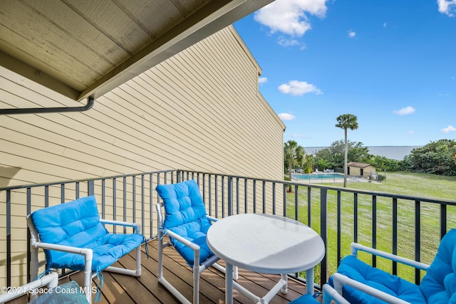 wooden deck with a lawn and a swimming pool