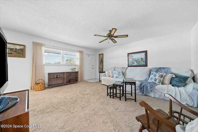 living room featuring ceiling fan, carpet, and a textured ceiling