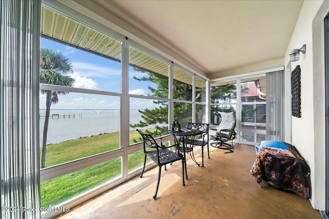 sunroom featuring a water view