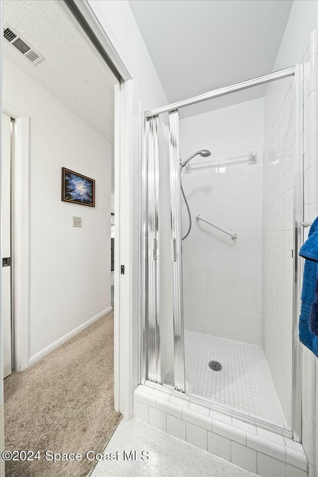 bathroom featuring a shower with shower door