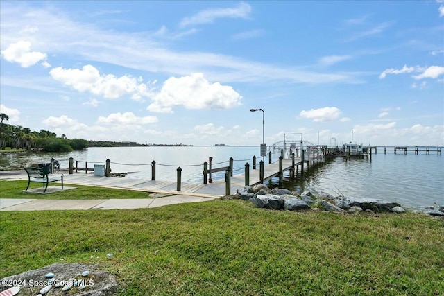 dock area with a water view and a lawn