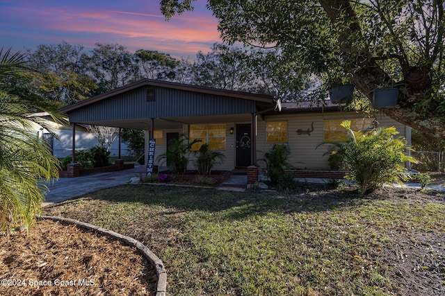 view of front of property with a lawn and a carport