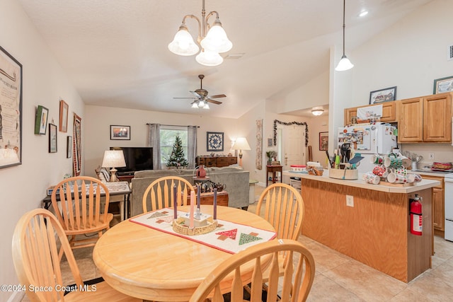 dining area featuring ceiling fan with notable chandelier, lofted ceiling, and light tile patterned floors