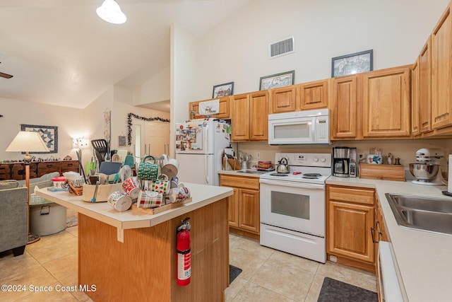 kitchen featuring white appliances, sink, a center island, a breakfast bar area, and light tile patterned flooring