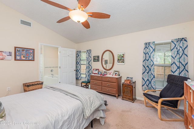 carpeted bedroom with ceiling fan, lofted ceiling, a textured ceiling, and connected bathroom