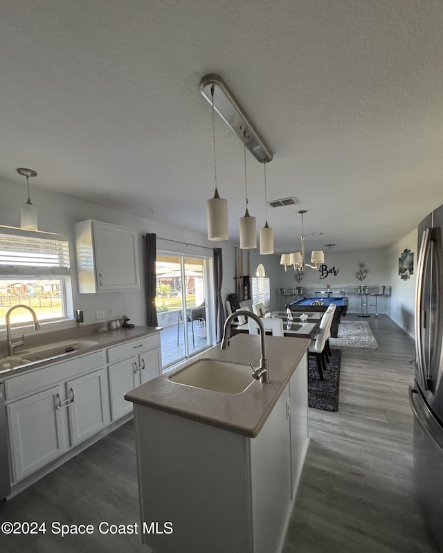 kitchen featuring a kitchen island with sink, sink, white cabinets, and plenty of natural light