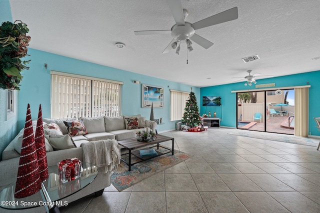 living room with ceiling fan, light tile patterned floors, a healthy amount of sunlight, and a textured ceiling