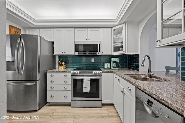 kitchen with white cabinets, light stone counters, sink, and stainless steel appliances