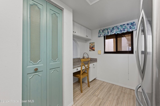 kitchen featuring white cabinets, light wood-type flooring, and stainless steel refrigerator