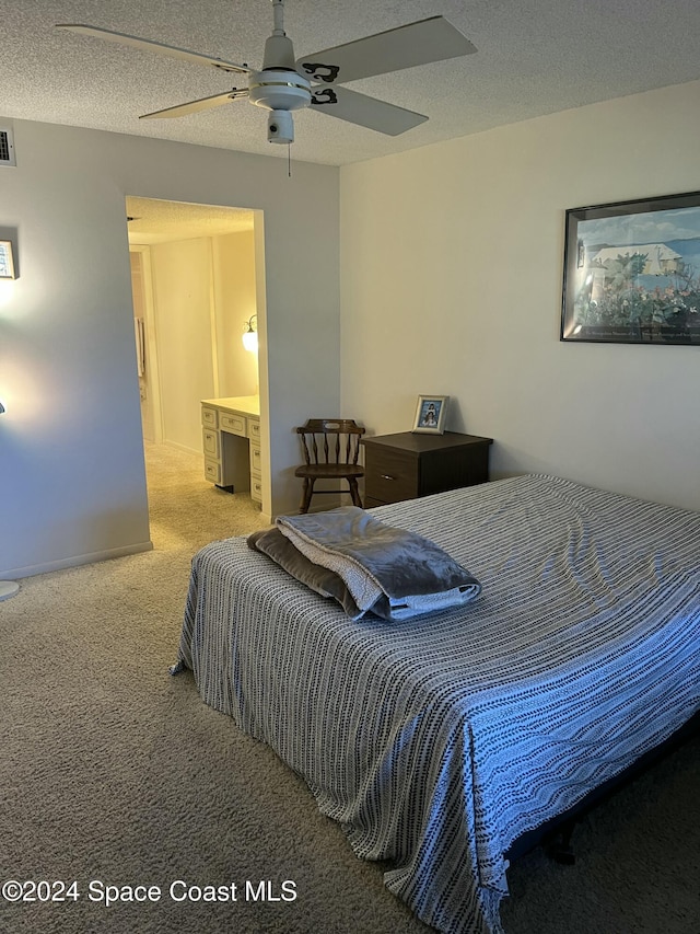 bedroom featuring ensuite bath, ceiling fan, carpet floors, and a textured ceiling