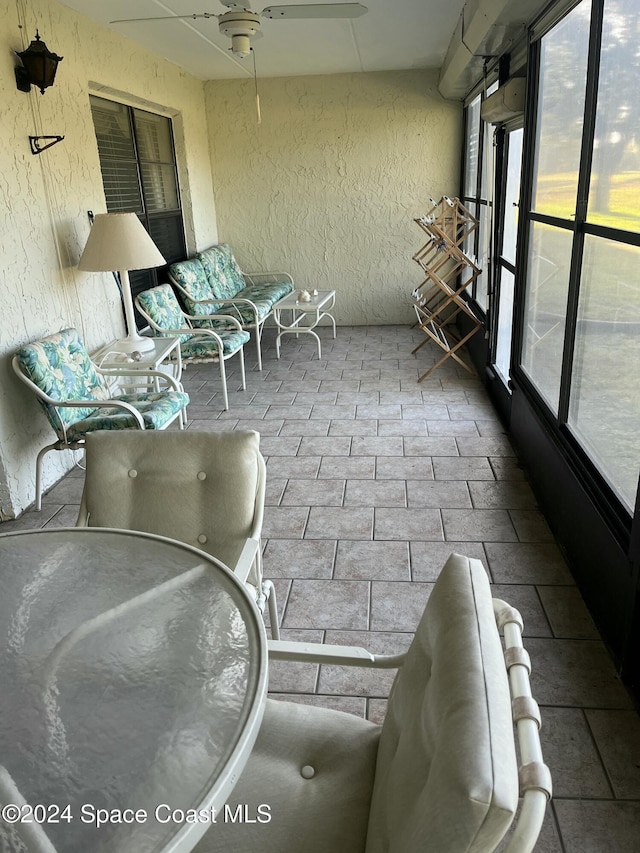 unfurnished sunroom featuring ceiling fan