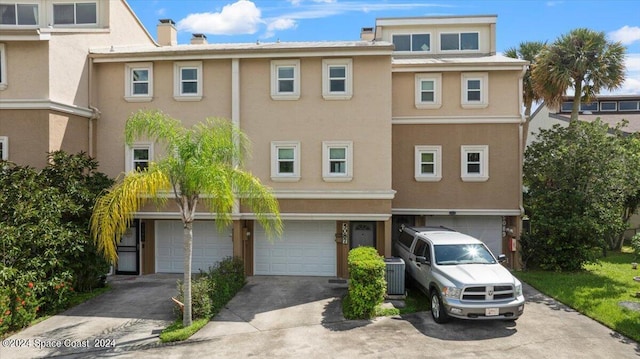 view of front of house with a garage and cooling unit