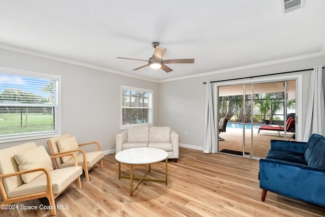 sitting room featuring a wealth of natural light, ceiling fan, ornamental molding, and light wood-type flooring