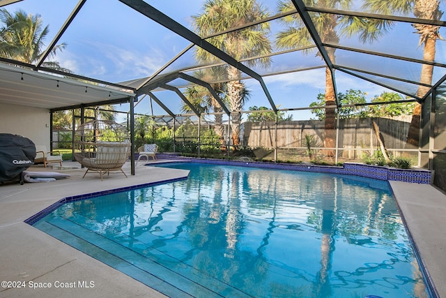 view of swimming pool featuring glass enclosure, a patio, and grilling area