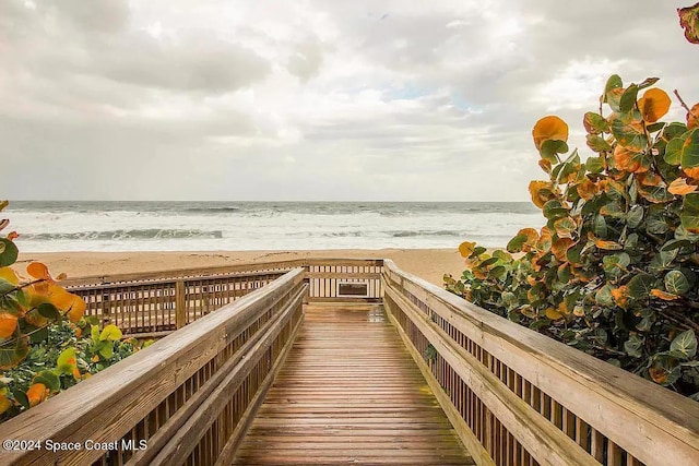 view of property's community featuring a beach view and a water view