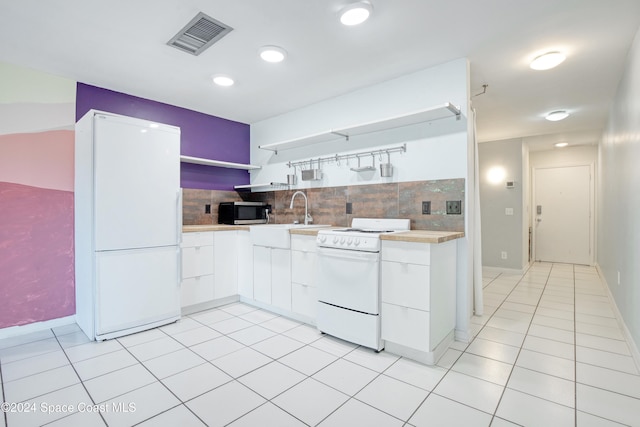 kitchen with tasteful backsplash, sink, white appliances, and white cabinets