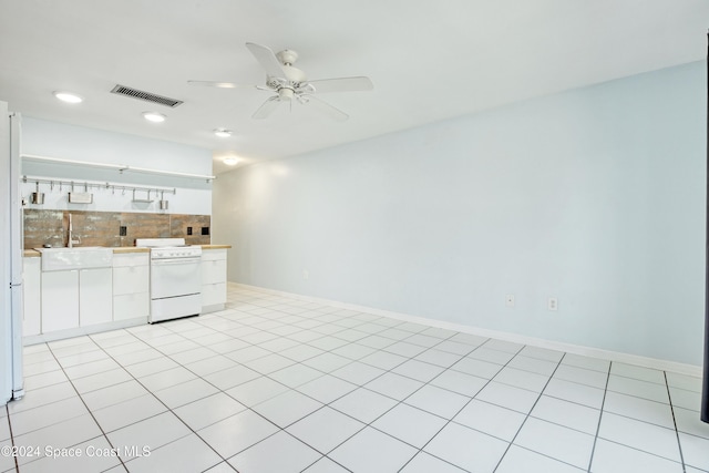 interior space with electric stove, ceiling fan, tasteful backsplash, and white cabinets