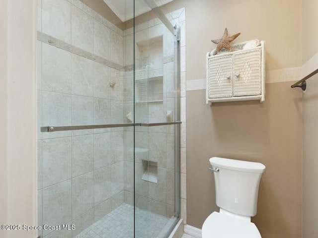 bathroom with toilet and a shower with shower door