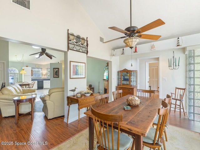 dining room featuring hardwood / wood-style flooring, high vaulted ceiling, and ceiling fan