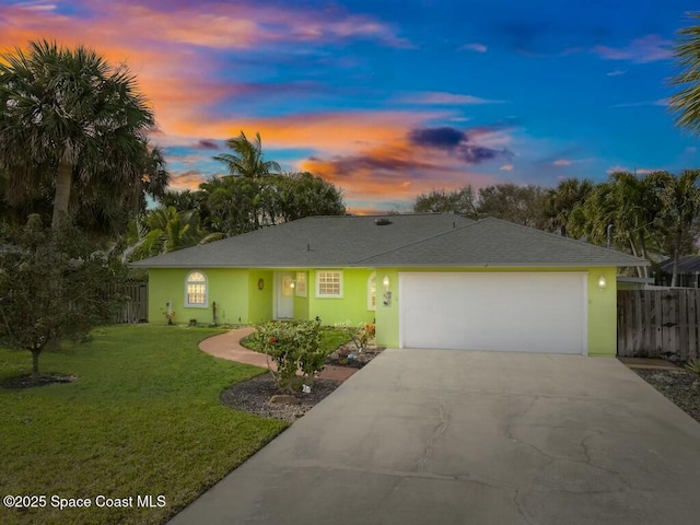 single story home featuring a garage and a lawn