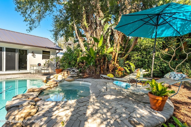 view of pool with an in ground hot tub and a patio