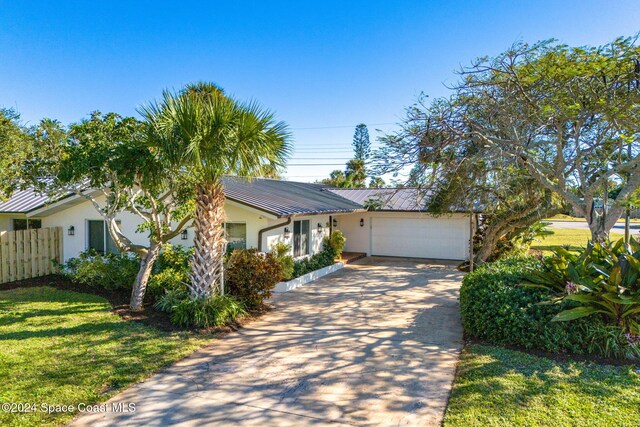401 S Palm Ave, Indialantic, FL 32903 - view of front of property featuring stucco siding, driveway, a metal roof, a garage, and a standing seam roof