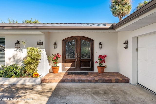 entrance to property featuring a garage and french doors