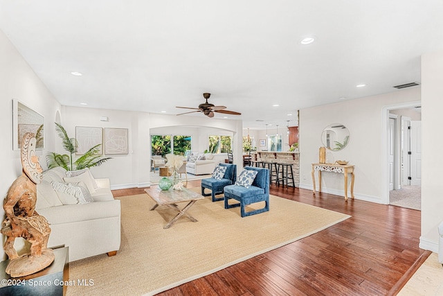 living room featuring hardwood / wood-style floors and ceiling fan