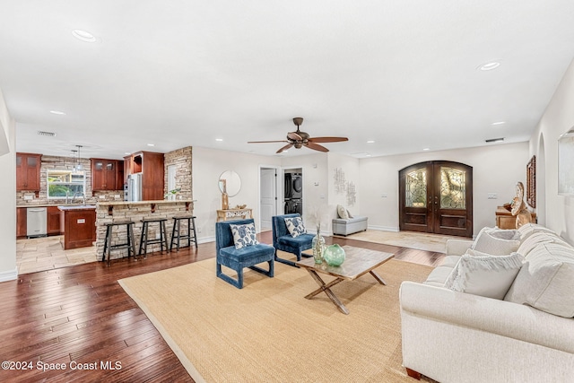 living room with hardwood / wood-style flooring, ceiling fan, and french doors