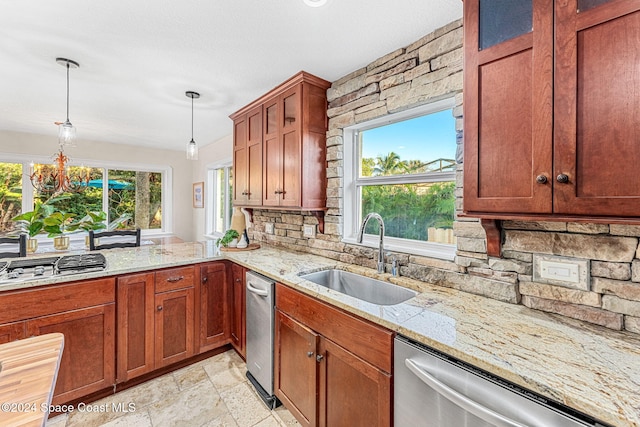 kitchen with sink, stainless steel appliances, light stone counters, backsplash, and decorative light fixtures