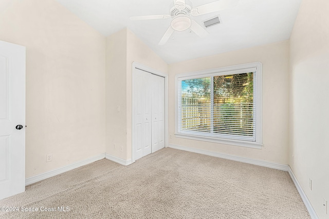 carpeted spare room with ceiling fan and lofted ceiling