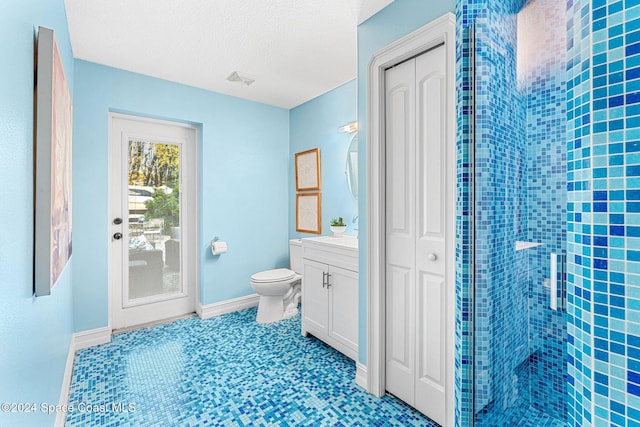 bathroom featuring a textured ceiling, vanity, toilet, and walk in shower