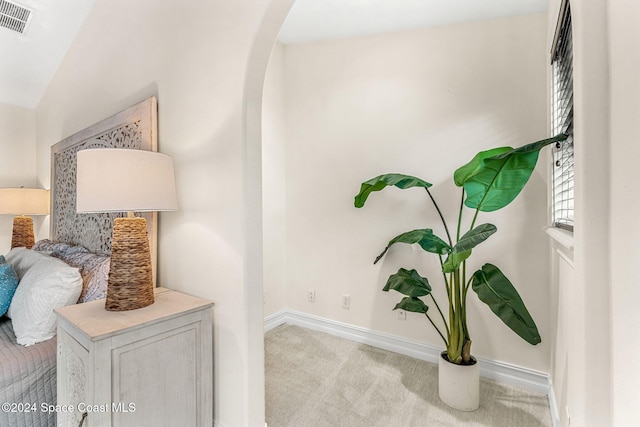 hallway featuring light colored carpet and vaulted ceiling