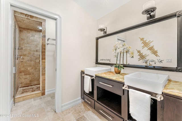 bathroom with a textured ceiling, vanity, and an enclosed shower