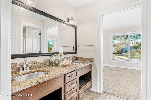 bathroom featuring tile patterned flooring, vanity, and a healthy amount of sunlight