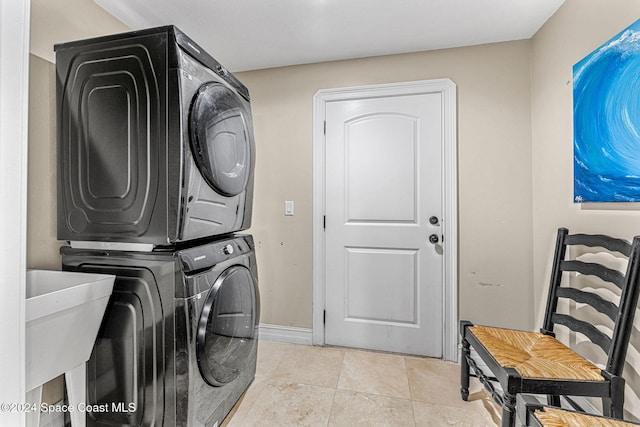 laundry room featuring light tile patterned floors and stacked washer and dryer