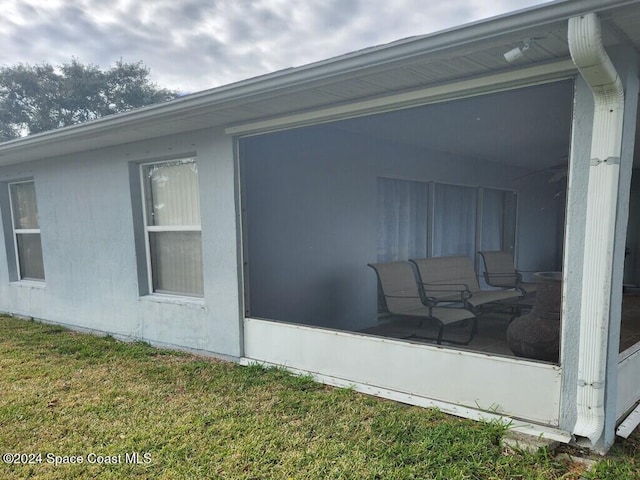 view of side of property featuring a sunroom and a yard