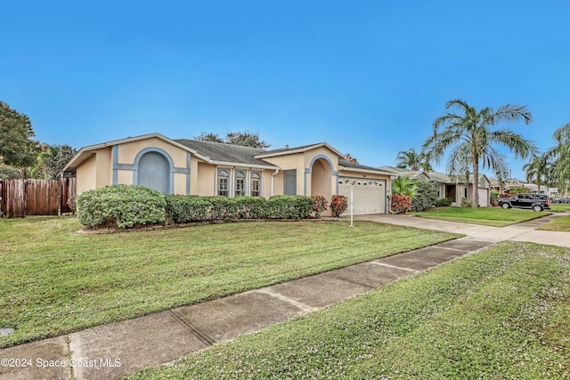 ranch-style house featuring a garage and a front lawn