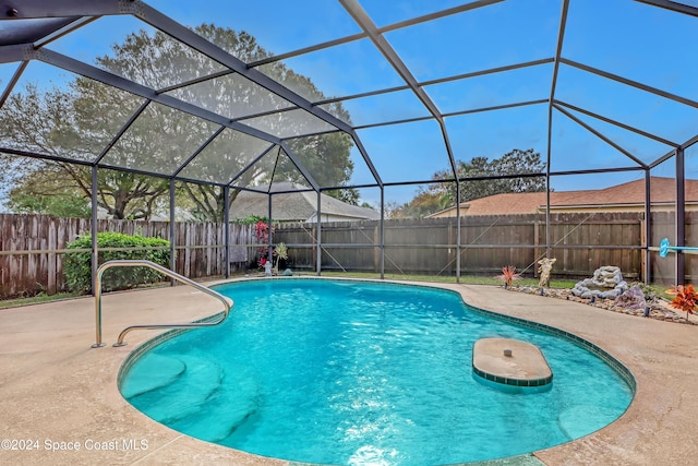 view of swimming pool with glass enclosure and a patio area