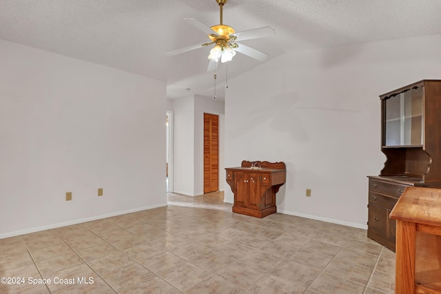 unfurnished living room with light tile patterned floors, a textured ceiling, vaulted ceiling, and ceiling fan