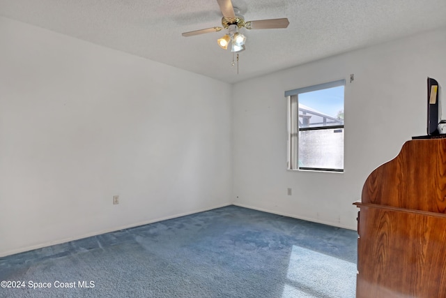 carpeted empty room with a textured ceiling and ceiling fan