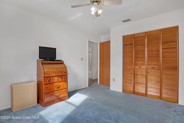 carpeted bedroom featuring ceiling fan and a closet