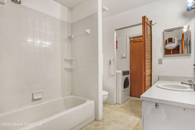 full bathroom with tiled shower / bath, toilet, vanity, and washer / dryer