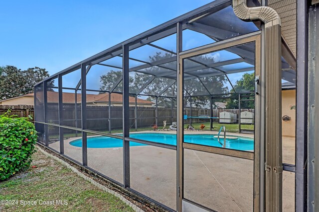 view of swimming pool with a lanai