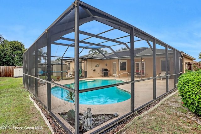 view of pool featuring glass enclosure, a patio area, and grilling area