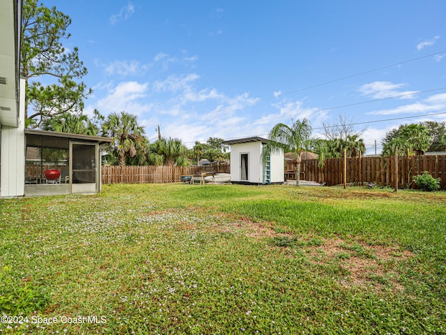 view of yard featuring a sunroom and a storage shed