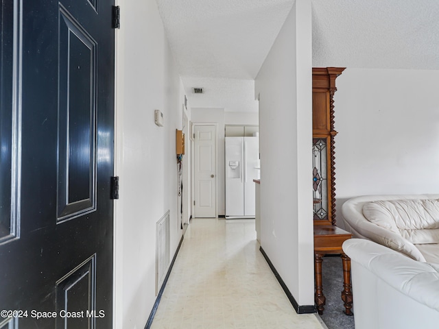 hall featuring a textured ceiling