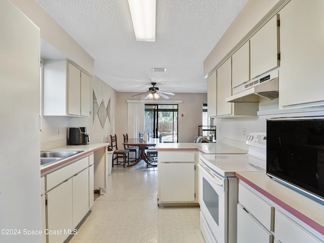 kitchen featuring a textured ceiling, sink, electric stove, and kitchen peninsula